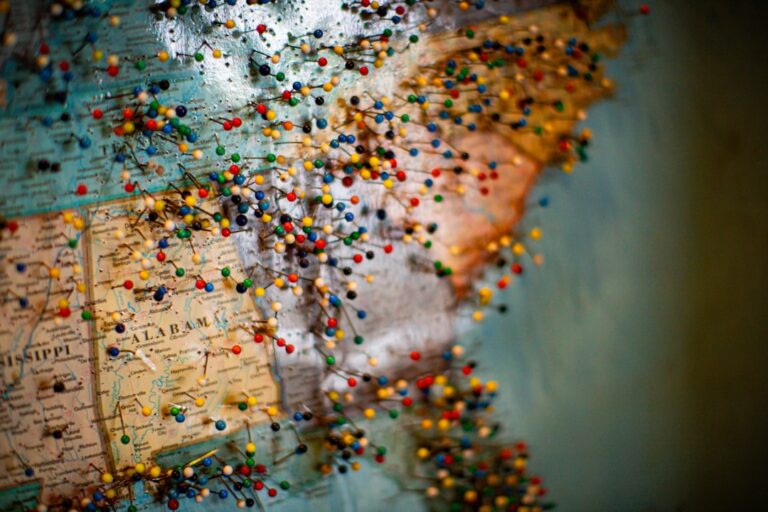 Using vintage postage stamps as escort card magnets on a suspended map backdrop